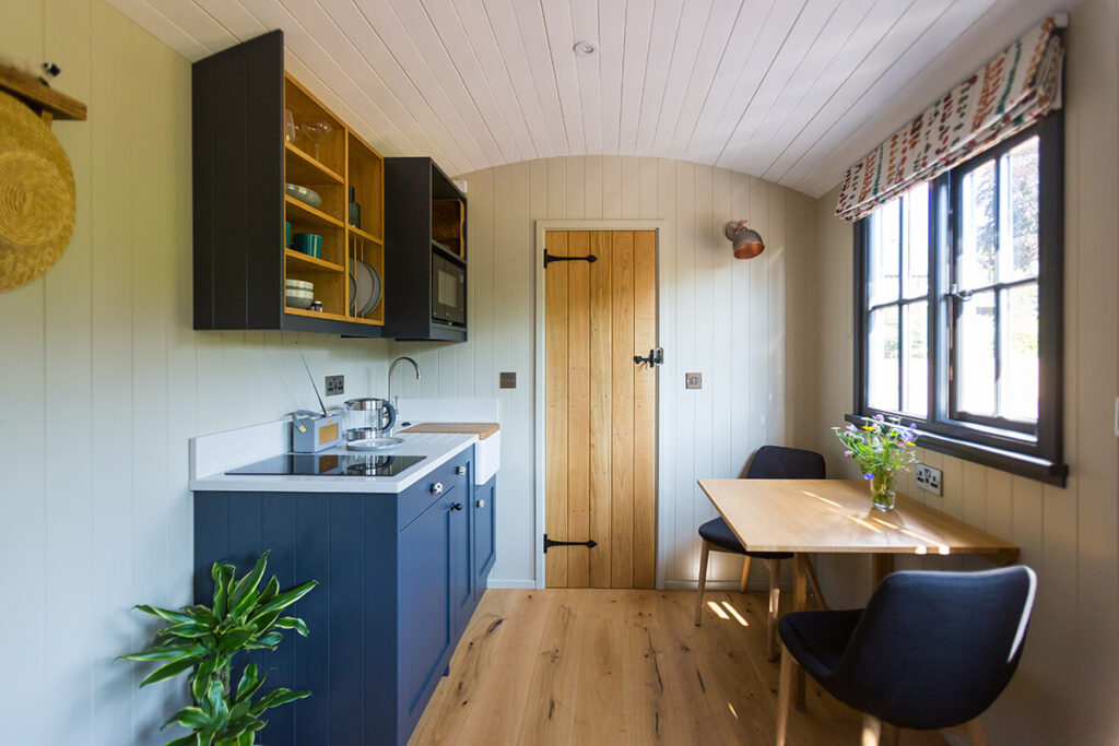 a view of the kitchen and dining area inside one of the beautifully fitted out shepherd huts at Settledown retreats