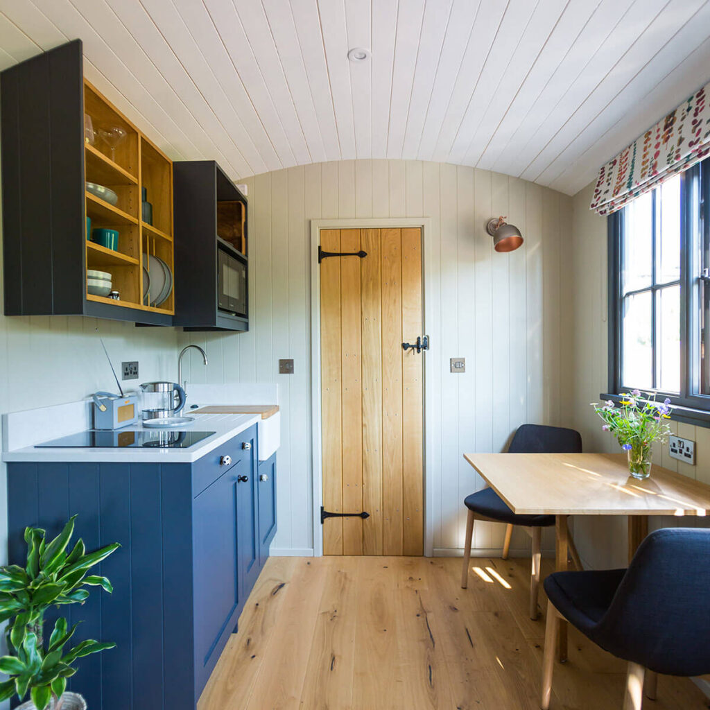 a view of the kitchen and dining area inside one of the beautifully fitted out shepherd huts at Settledown retreats